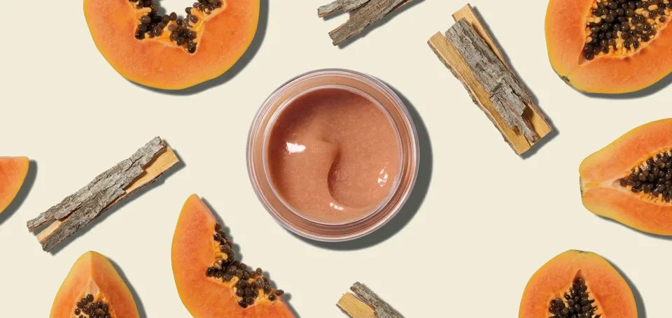 Papaya Enzyme Exfoliating Mask in an open jar with papaya slices and willow bark