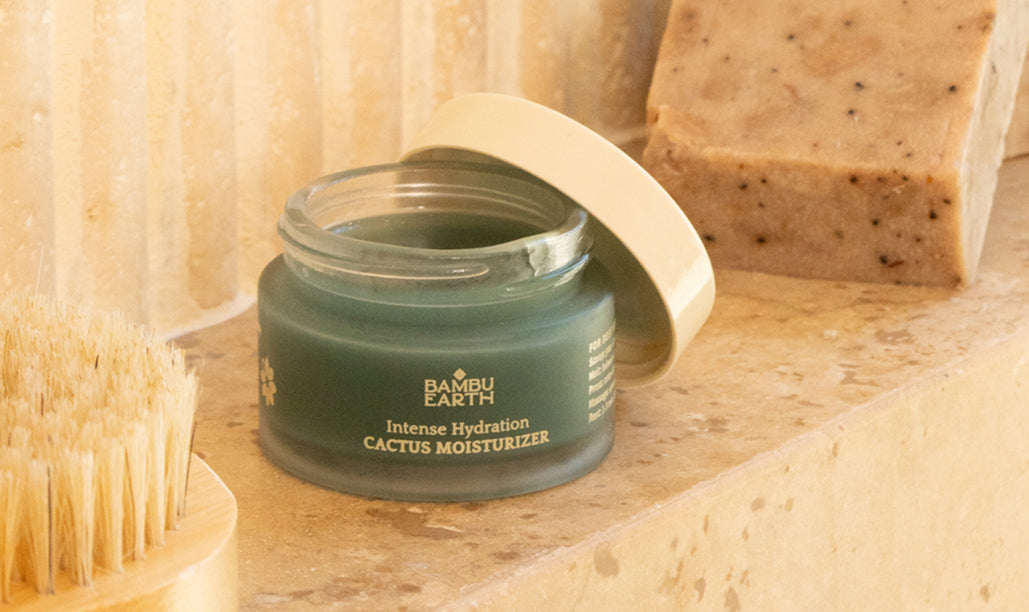 Open Cactus Moisturizer jar on a stone ledge beside a soap bar and brush