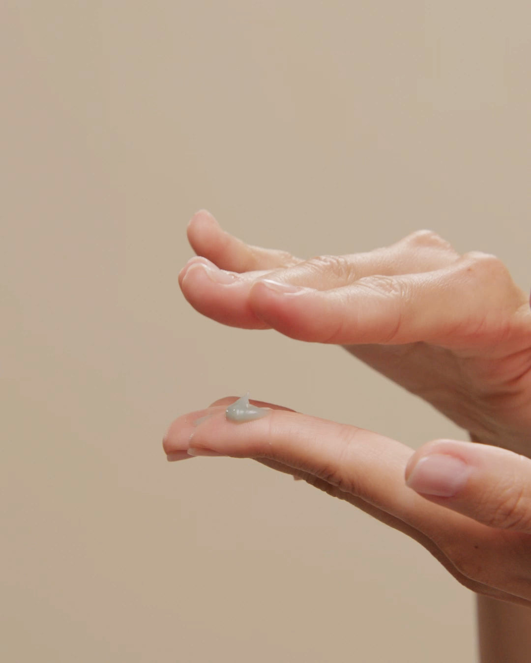 A dab of balm on a fingertip between two open palms
